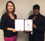 Team Lead, Lauren Hoffman,  presents Kendra Parker (Right) with  an Award of Excellence.