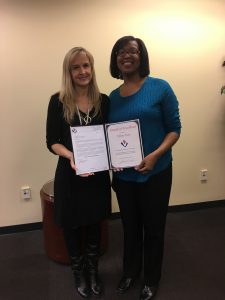 Kathy McKenzie (left) presents an  Award of  Excellence to Tiffany Jones