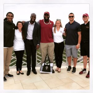 VMSI's Kylene Henson (right) and Megan Shelton  pose with Redskins players.