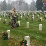 A soldier laying wreaths