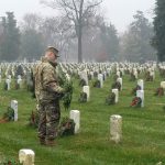 A soldier laying wreaths